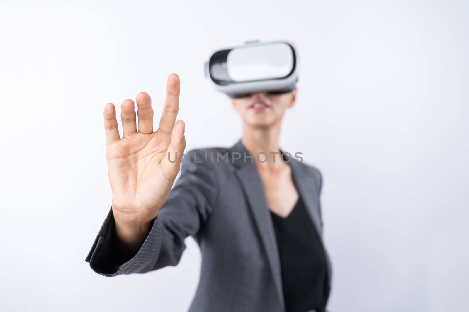 Professional female leader touching at program or working while using VR glasses. Skilled businesswoman pointing at system while connecting at metaverse by wearing visual reality goggles. Contraption.