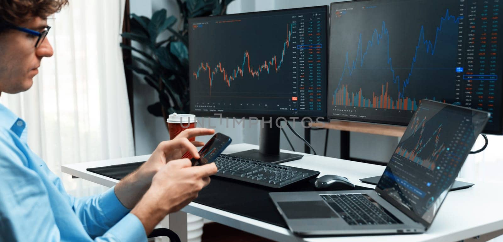 Young investor in stock trader looking on smartphone of dynamic financial exchange investment surrounded current market graph screen in real time at modern office, analyzing statistic profit. Gusher.