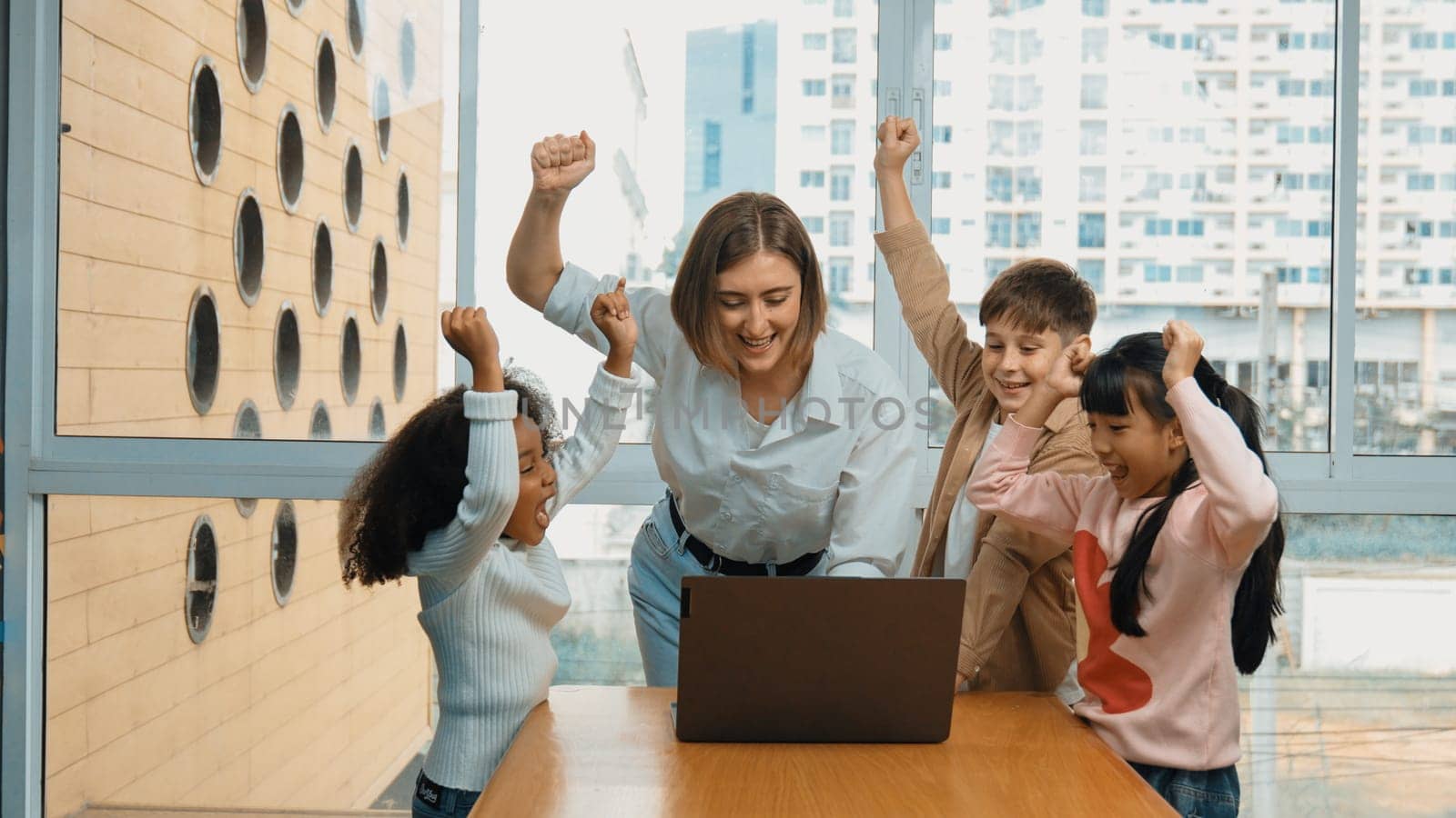 Group of diverse student and teacher celebrate successful project. Happy caucasian instructor looking at engineering code and cheering and encourage learner to improve skill at STEM class. Erudition.