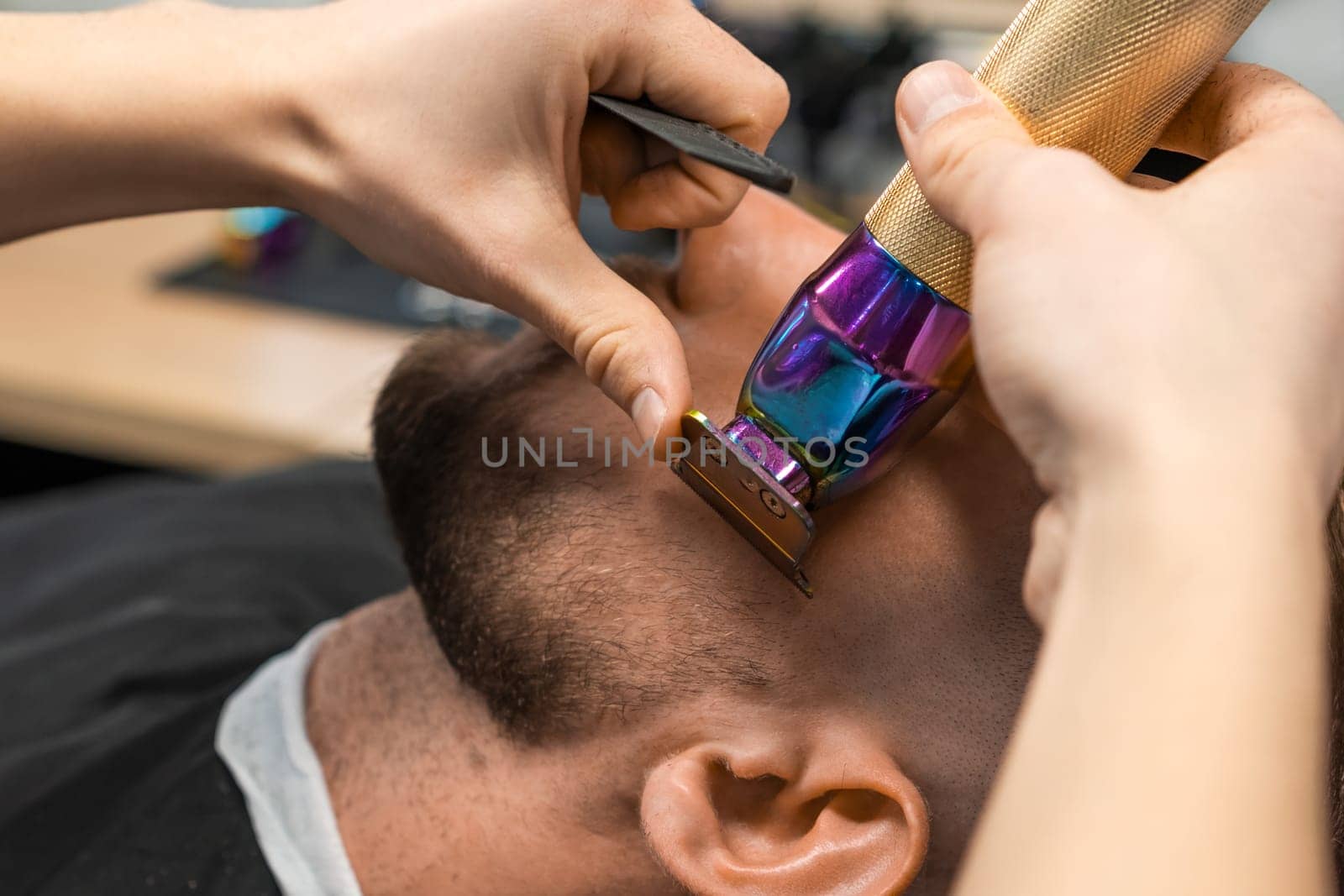 Barber cuts straight beard contour on man neck in barbershop closeup. Skilled hairstylist with clipper creates elegant beard haircut