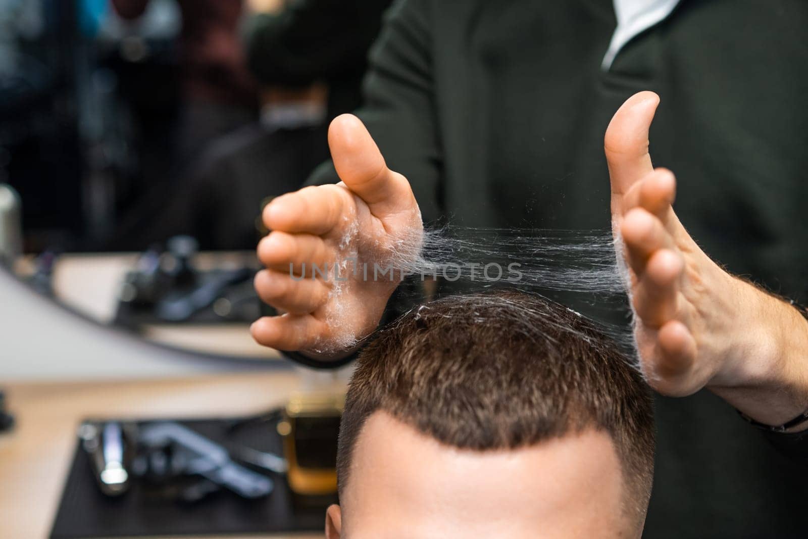 Barber expertly styling a clients hair with skilled hands in the barbershop.