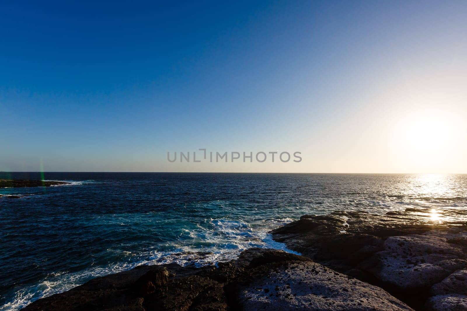 Evening scene on sea, stones, calm ocean.