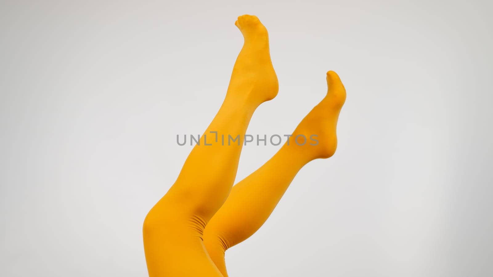 Female legs in ocher tights on a white background. Copy space