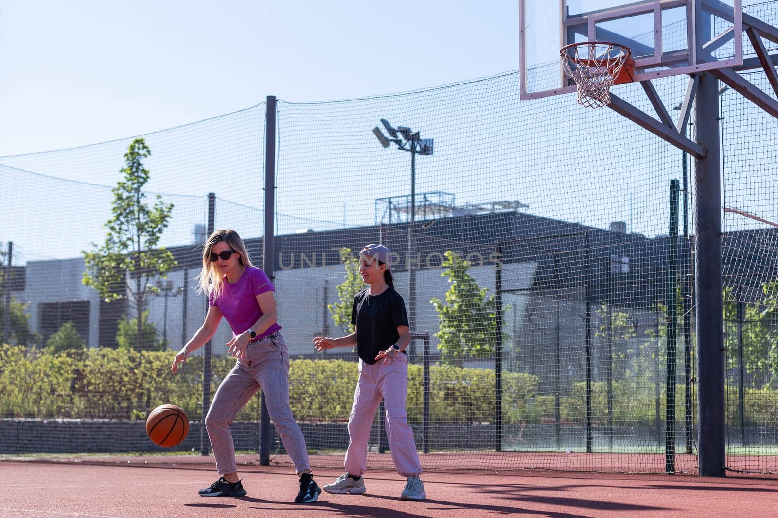 A Happy mother and child daughter outside at basketball court. High quality photo