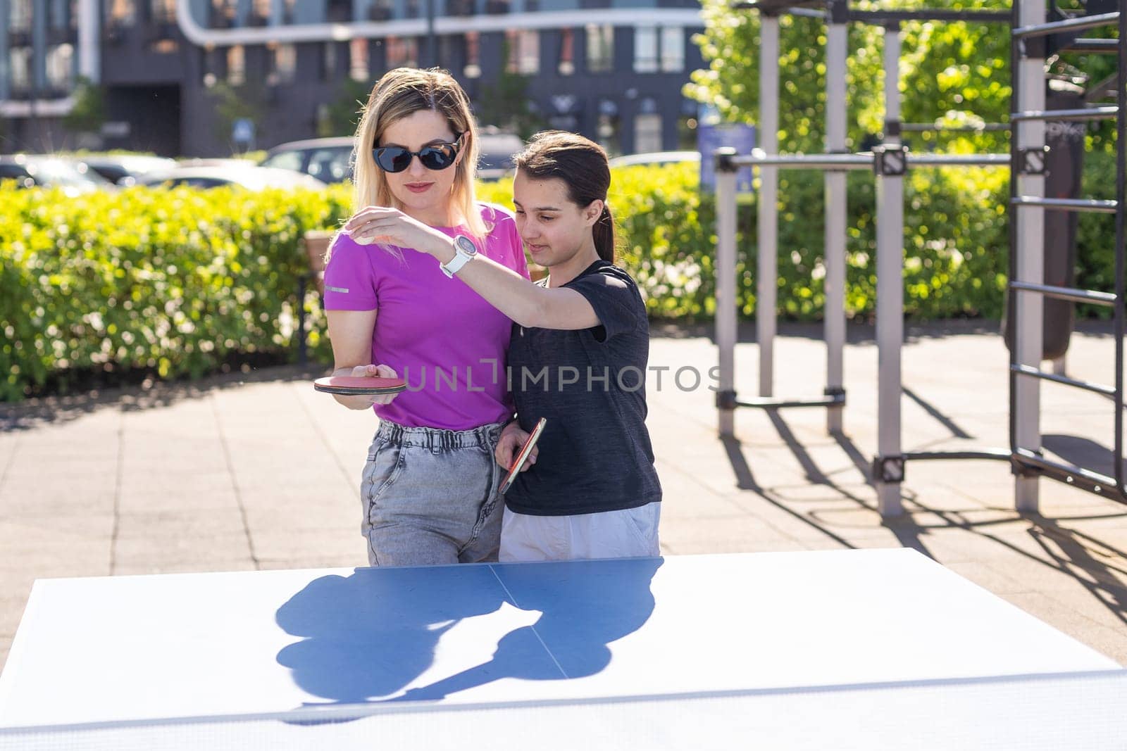 table tennis. mother and daughter play ping pong game. by Andelov13