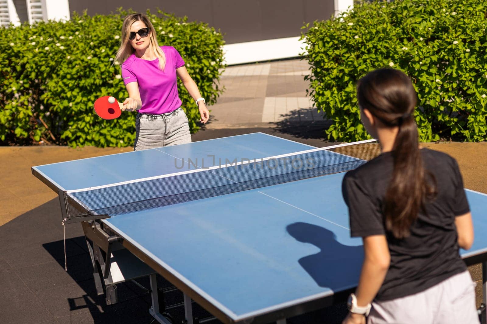 table tennis. mother and daughter play ping pong game. by Andelov13