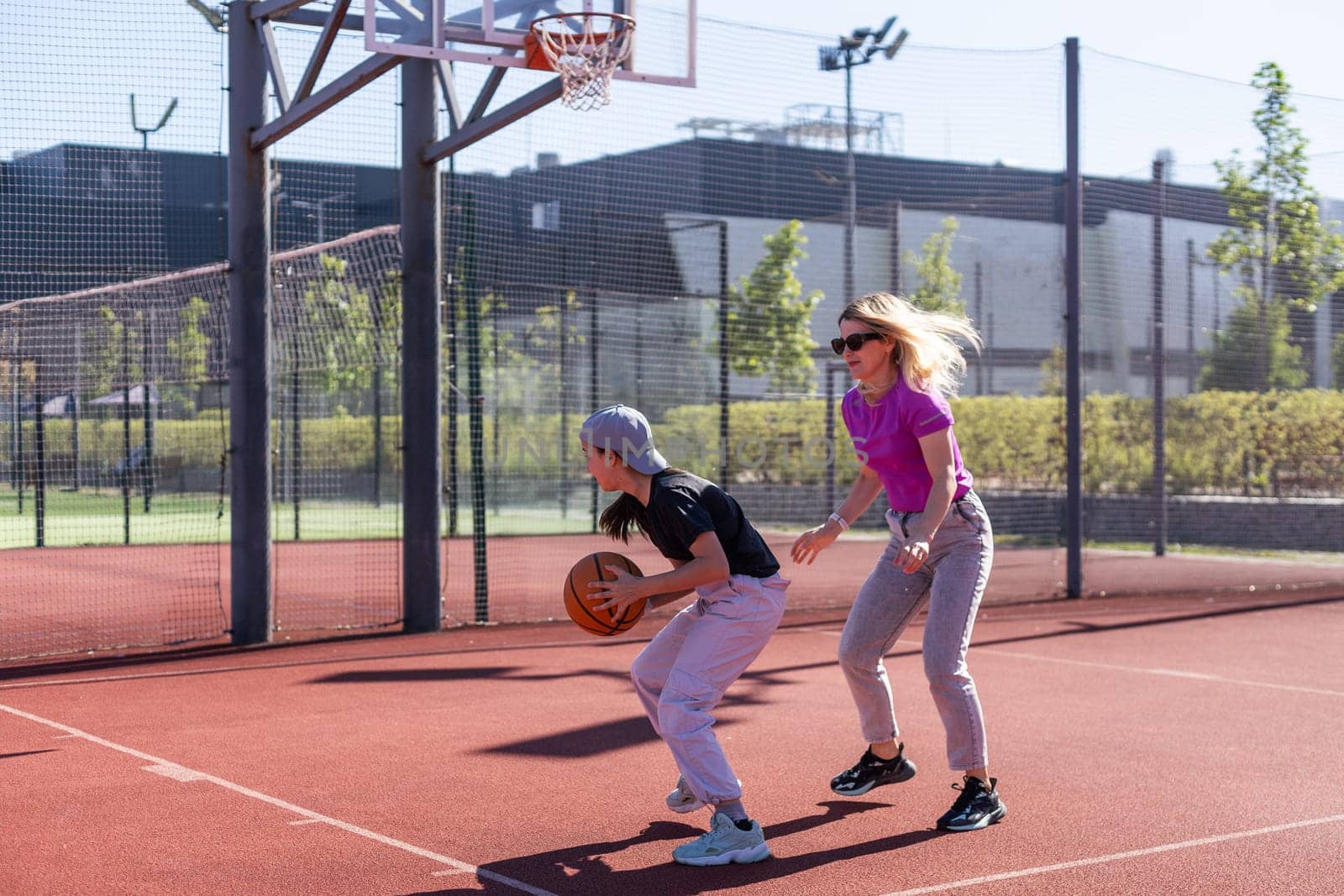 A Happy mother and child daughter outside at basketball court. High quality photo
