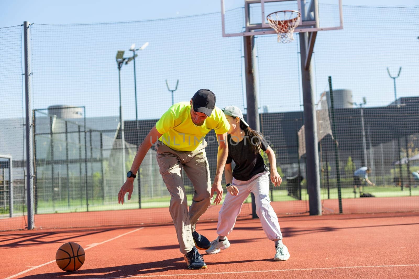 A father and daughter playing basketball in the park by Andelov13