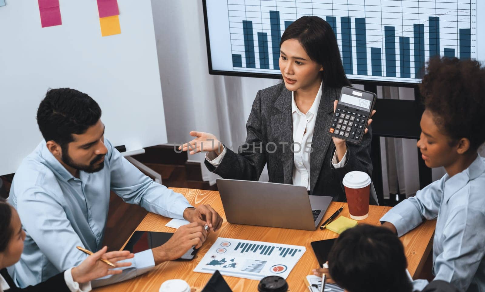 Top view multiracial analyst team use BI dashboard data to analyze financial report on meeting table. Group of diverse business people utilize data analysis by FIntech for business decision. Concord