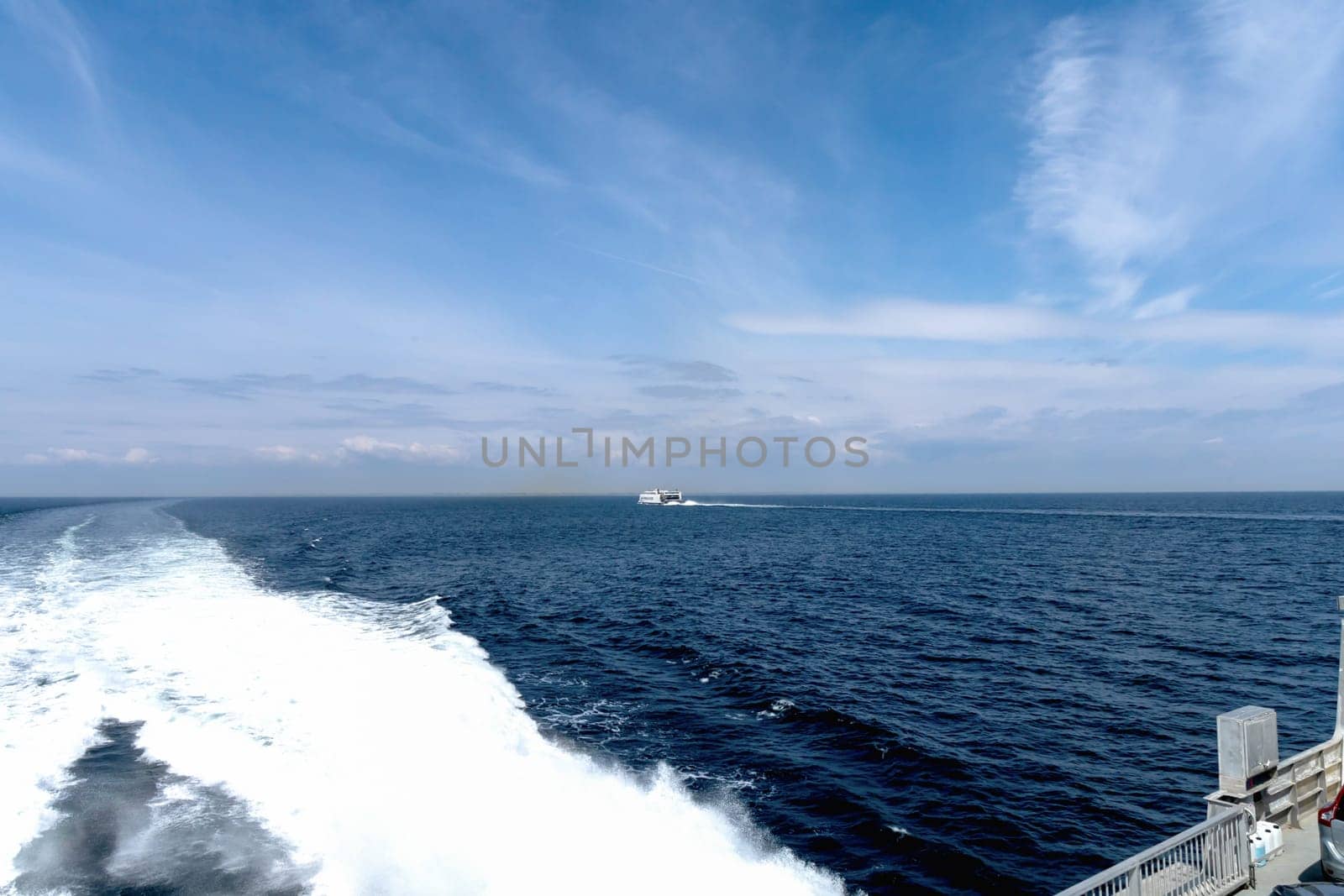 Seascape with a white ferry in the distance and waves. Sea transport