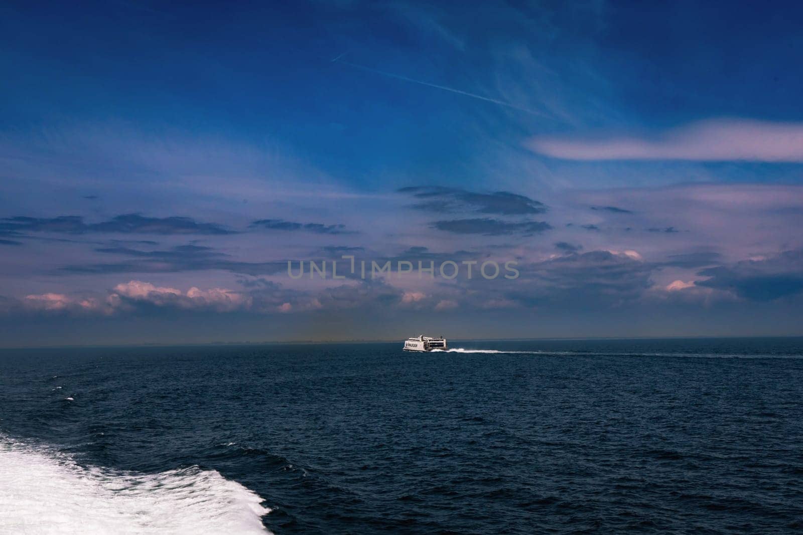 Seascape with a white ferry in the distance and waves. Sea transport