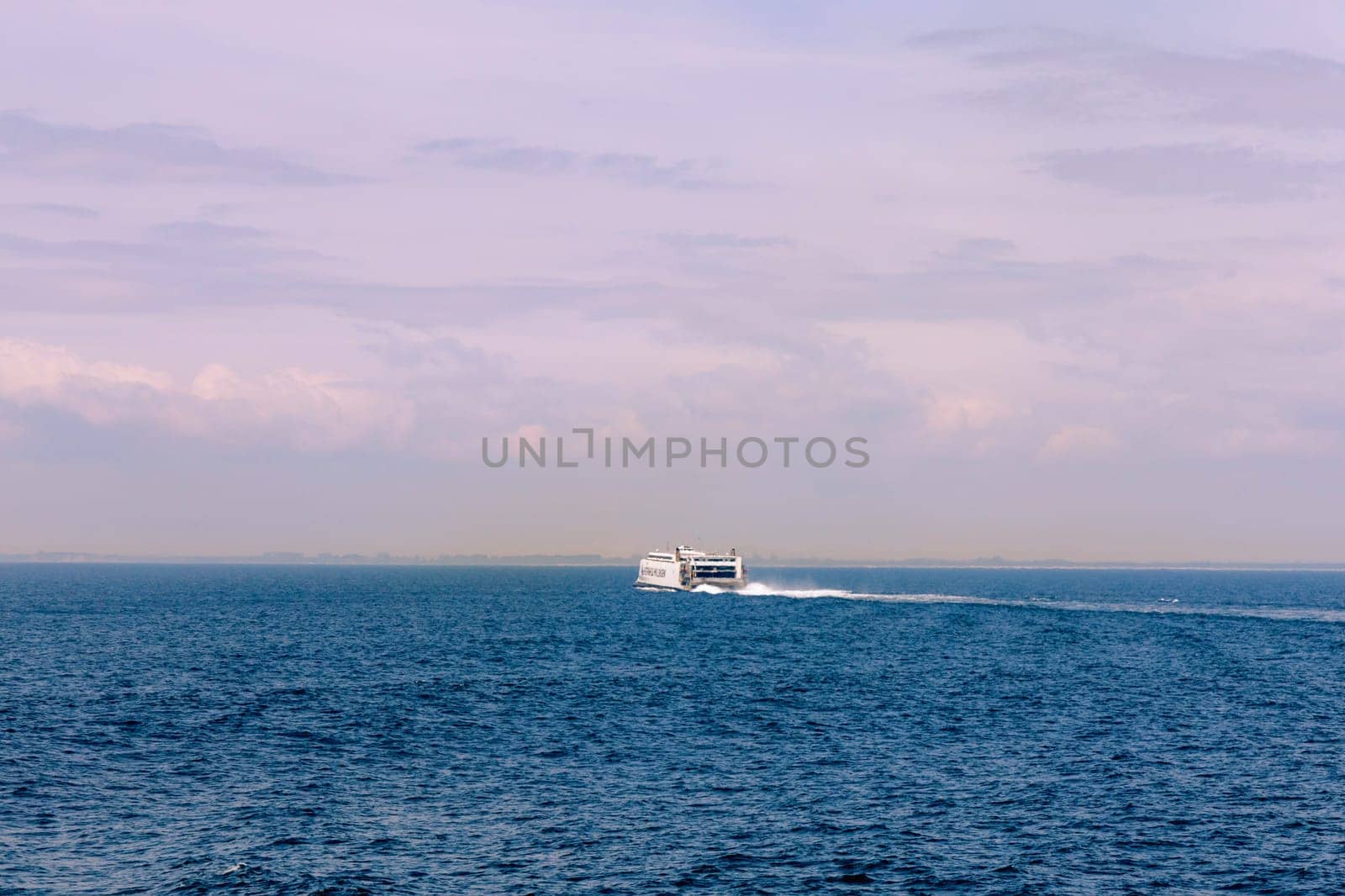 Seascape with a white ferry in the distance and waves. Sea transport