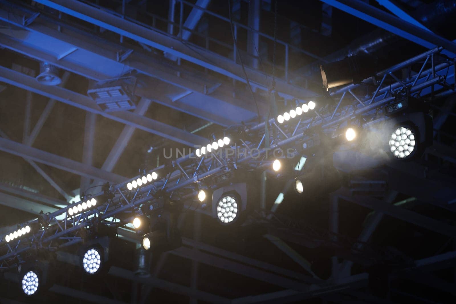 Stage lighting equipment indoor stage. Entertainment concert lighting. Led lighting devices under roof.