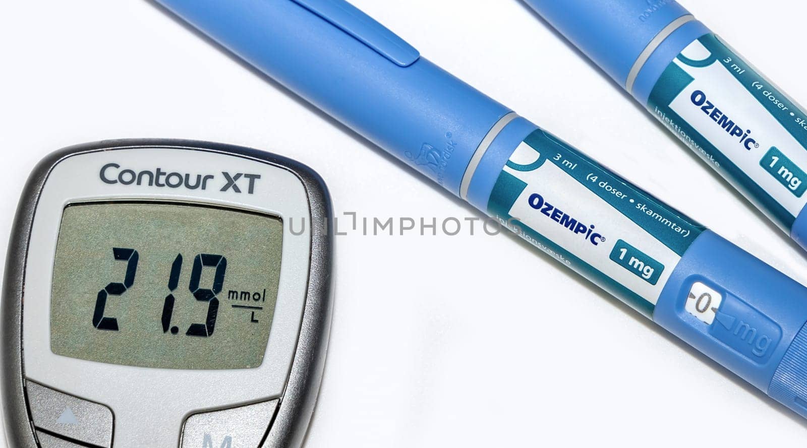 Blood sugar meter with test strips indicates high blood sugar levels and Ozempic injection pen for diabetes. Denmark - February 10, 2024