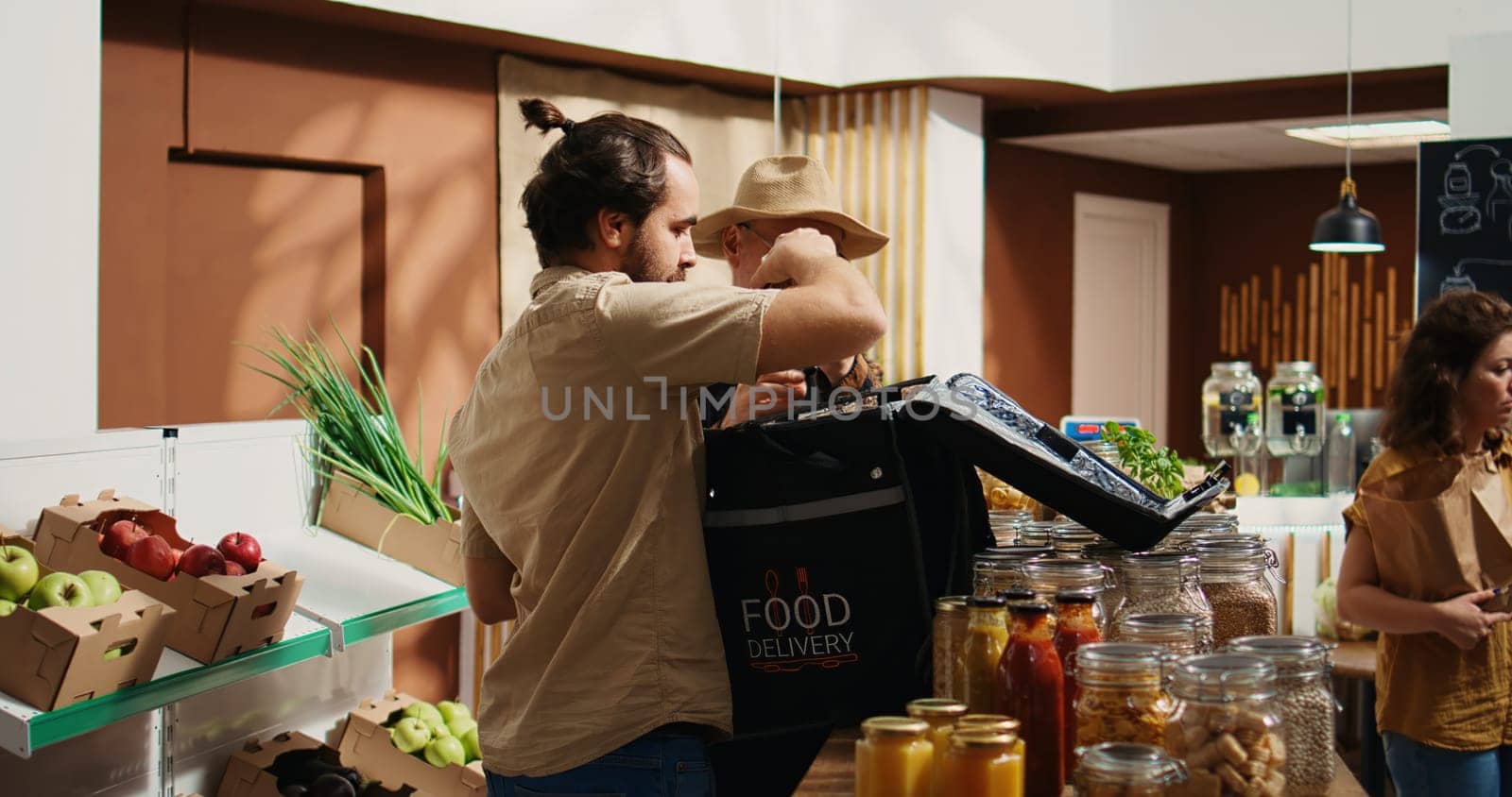Deliveryman arriving in sustainable supermarket to pick up organic food order for client. Man delivering farm grown fruits from local neighborhood shop, receiving groceries from senior storekeeper