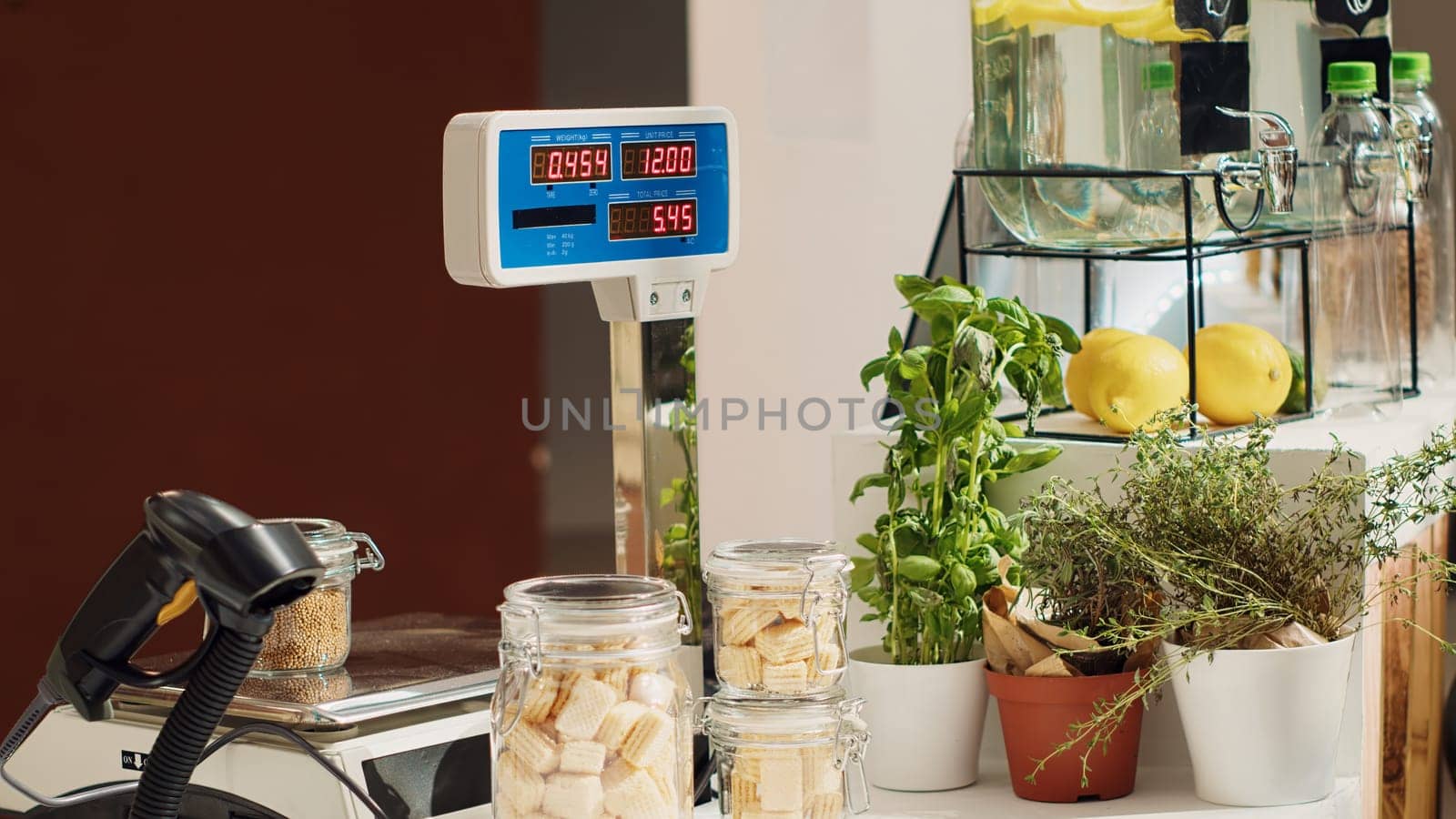 Close up of electronic scale in eco friendly zero waste supermarket next to organic produce. Panning shot of weighing machine in local neighborhood shop used for bulk products