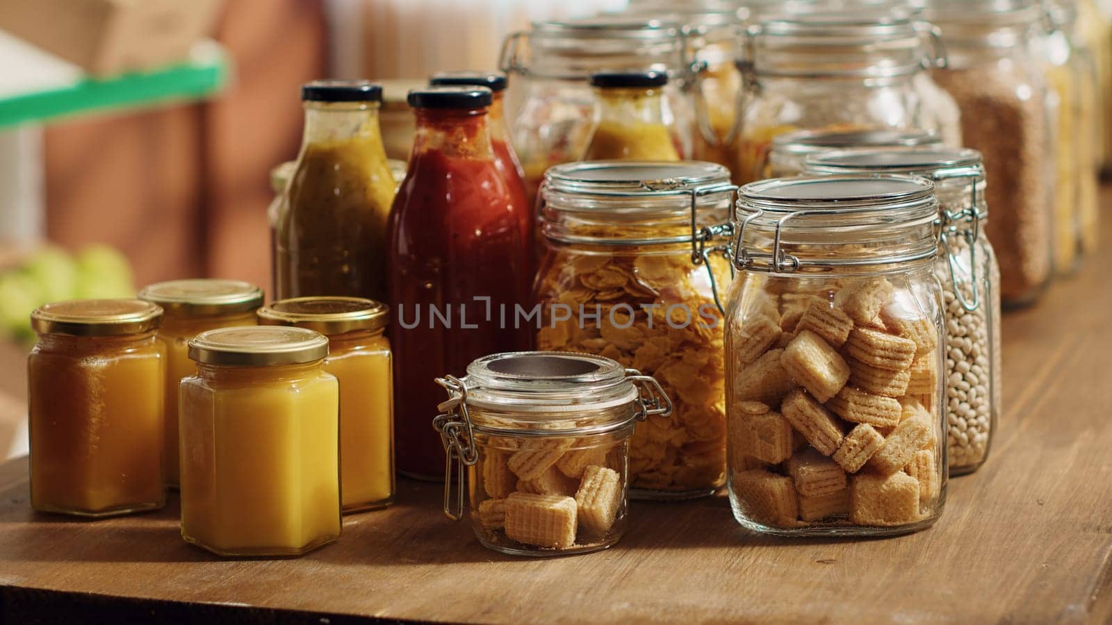 Close up on bulk food items in reusable glass jars used by environmentally friendly supermarket to lower climate impact. Local shop pantry staples in biodegradable nonpolluting packaging, panning shot