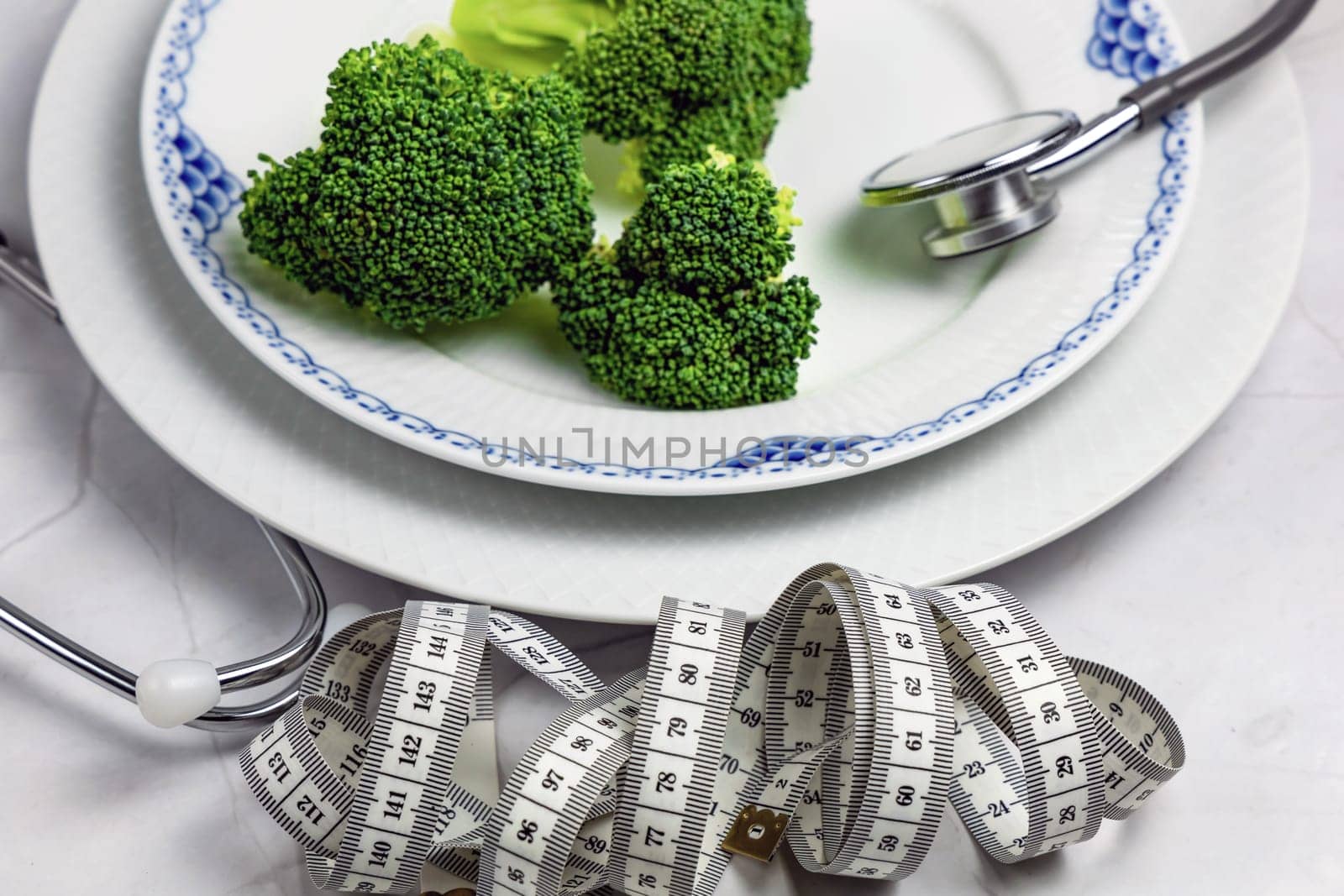 Concept of healthy eating and weight loss. Plate of green broccoli.