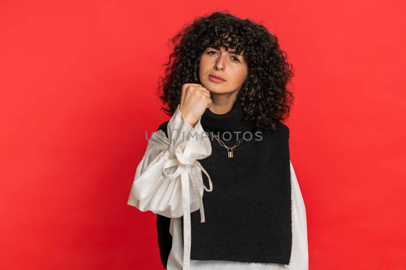 Quarrel. Displeased young woman gesturing hands with irritation and displeasure, blaming scolding for failure, asking why this happened. Brunette attractive girl isolated on red studio background