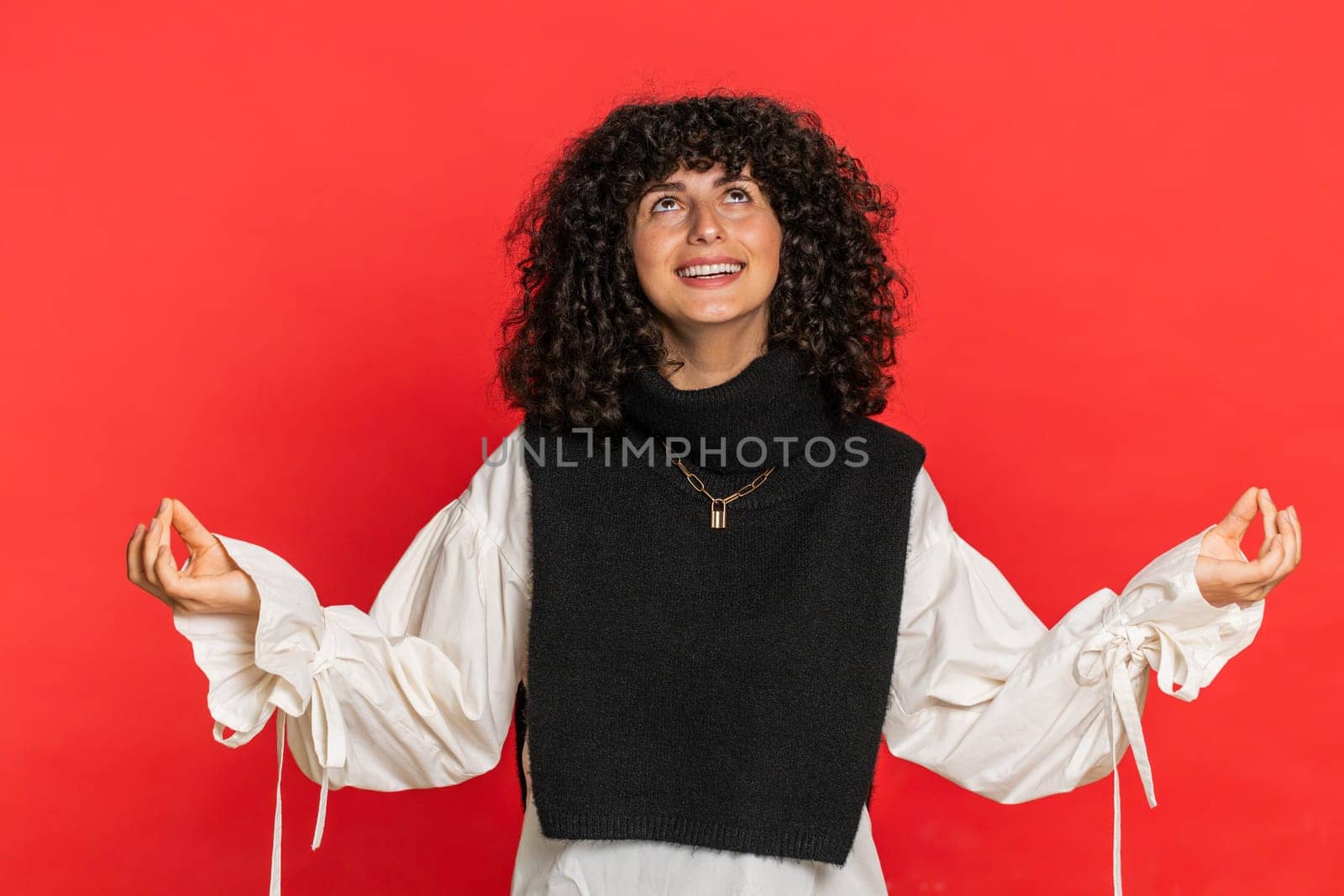 Keep calm down, relax, inner balance. Young woman breathes deeply with mudra gesture, eyes closed, meditating with concentrated thoughts, peaceful mind. Attractive girl isolated on red background