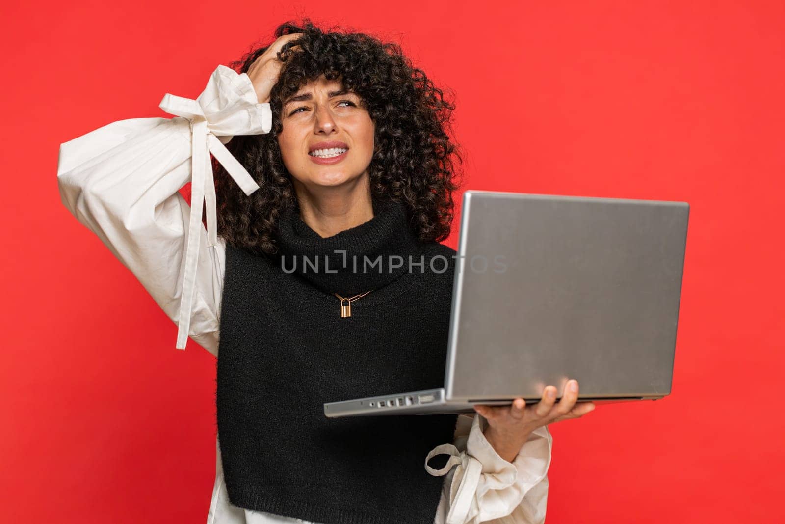 Displeased woman with curly hair use laptop notebook typing browsing working, loses becoming surprised sudden lottery results bad news fortune loss game fail computer virus. Girl on red background