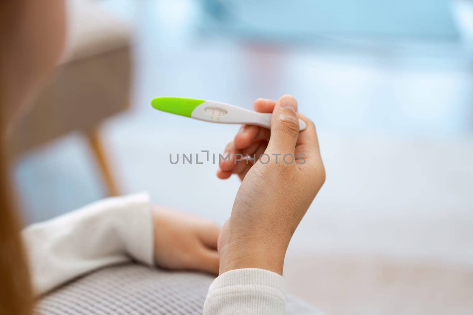 young woman hold in hands positive or negative pregnancy test thinking pondering, millennial female expecting baby undergo fertility infertility treatment by itchaznong