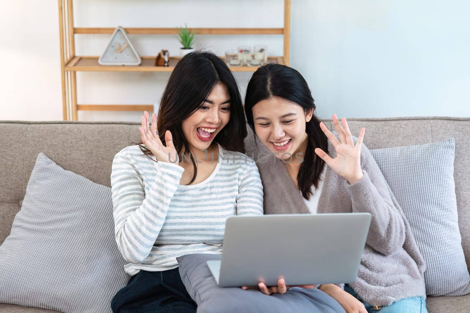 pride month Happy woman lesbian gay lgbt couple using laptop to video call with family, friends. LGBTQ couple concept by itchaznong