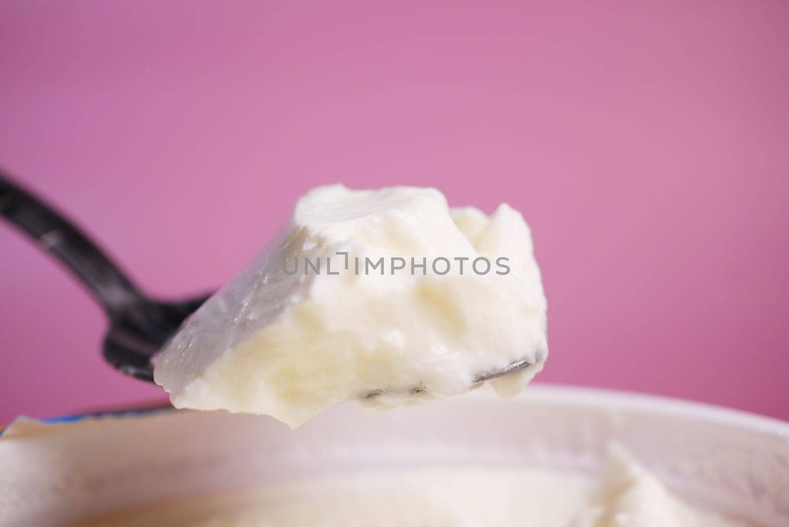 spoon pick fresh yogurt from a bowl .