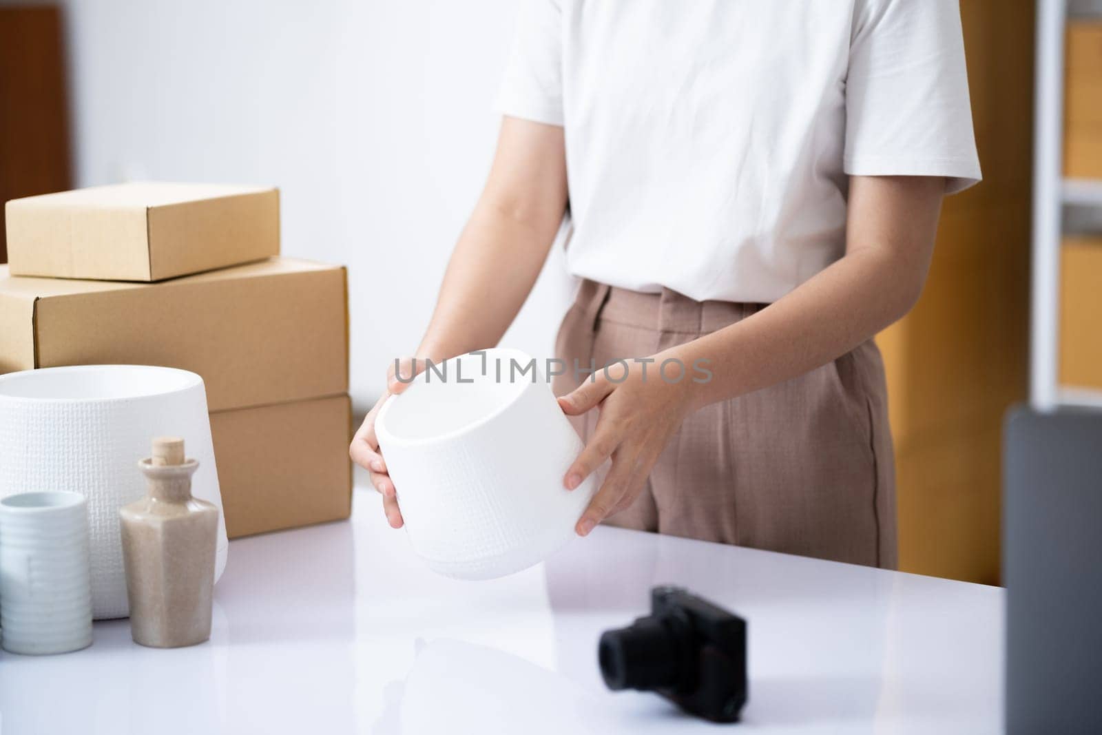 Attentive business owner thoroughly examining a product to ensure top quality before dispatch in her online shop workspace.