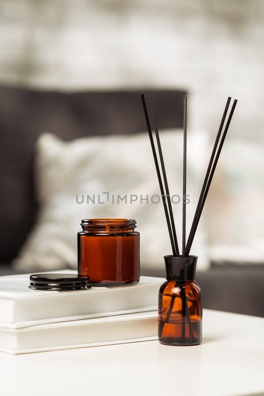 Aroma diffuser bottle with sticks in living room, close up