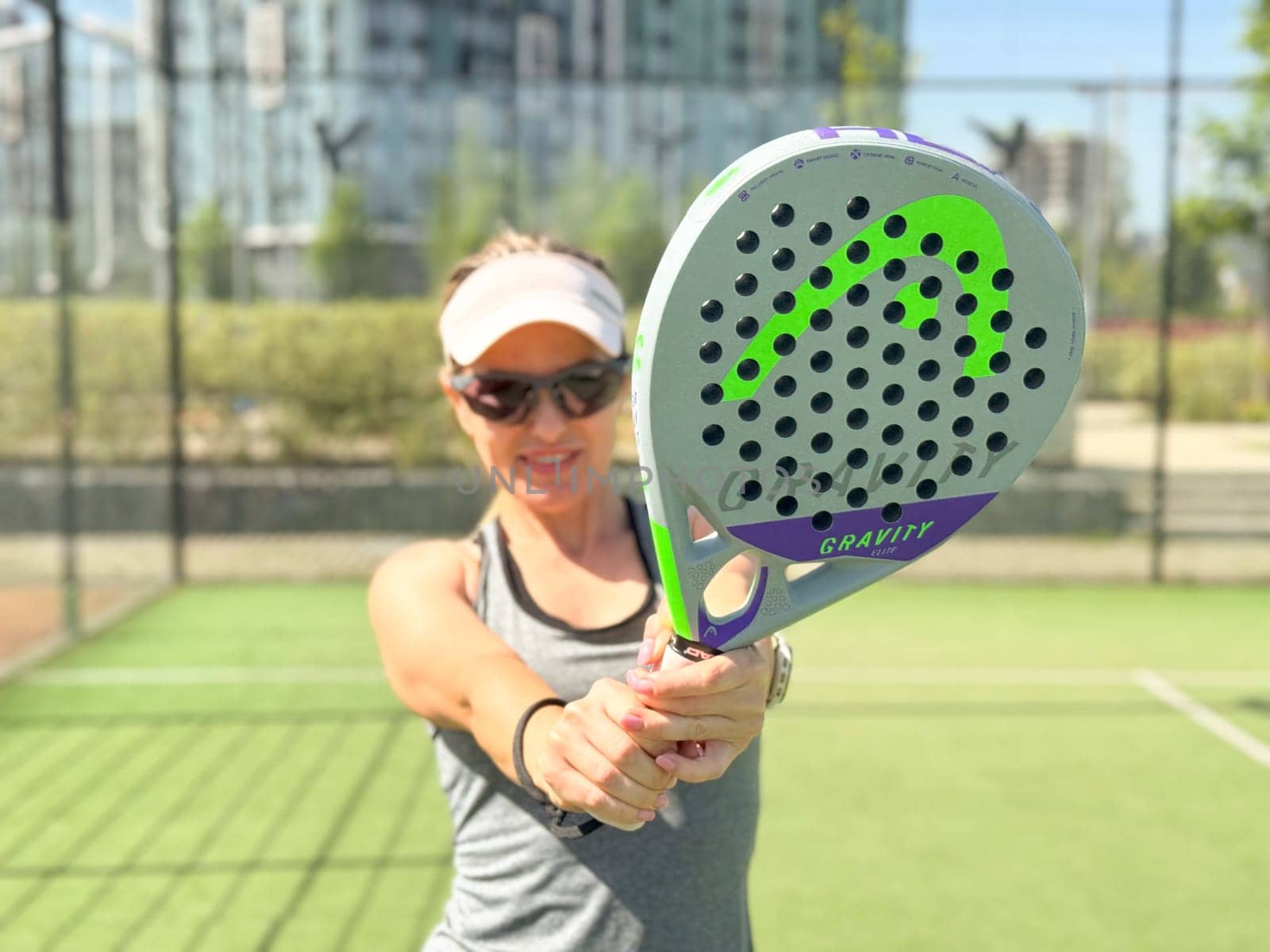 Ukraine Kyiv, May 03 2024. Portrait of smiling woman with padel tennis racket head at court. High quality photo