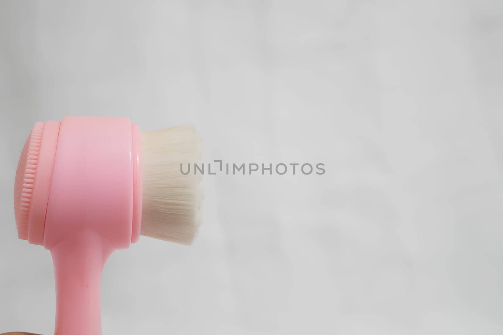 A pink and white brush is shown on a white background. High quality photo