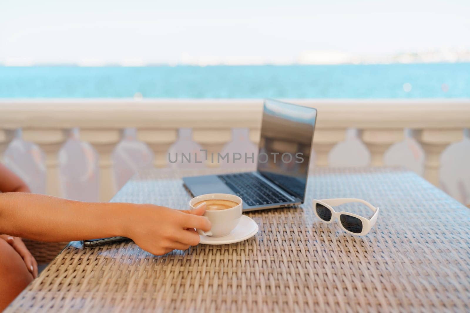 Woman coffee cafe macbook. Woman sitting at a coffee shop with mobile phone drinking coffee and looking away. Caucasian female relaxing at a cafe.