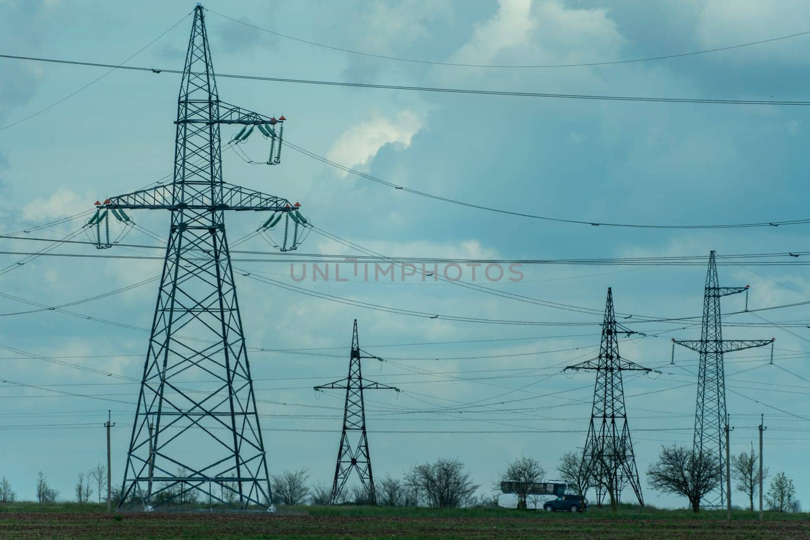 High voltage towers with sky background. Power line support with wires for electricity transmission. High voltage grid tower with wire cable at distribution station. Energy industry, energy saving.