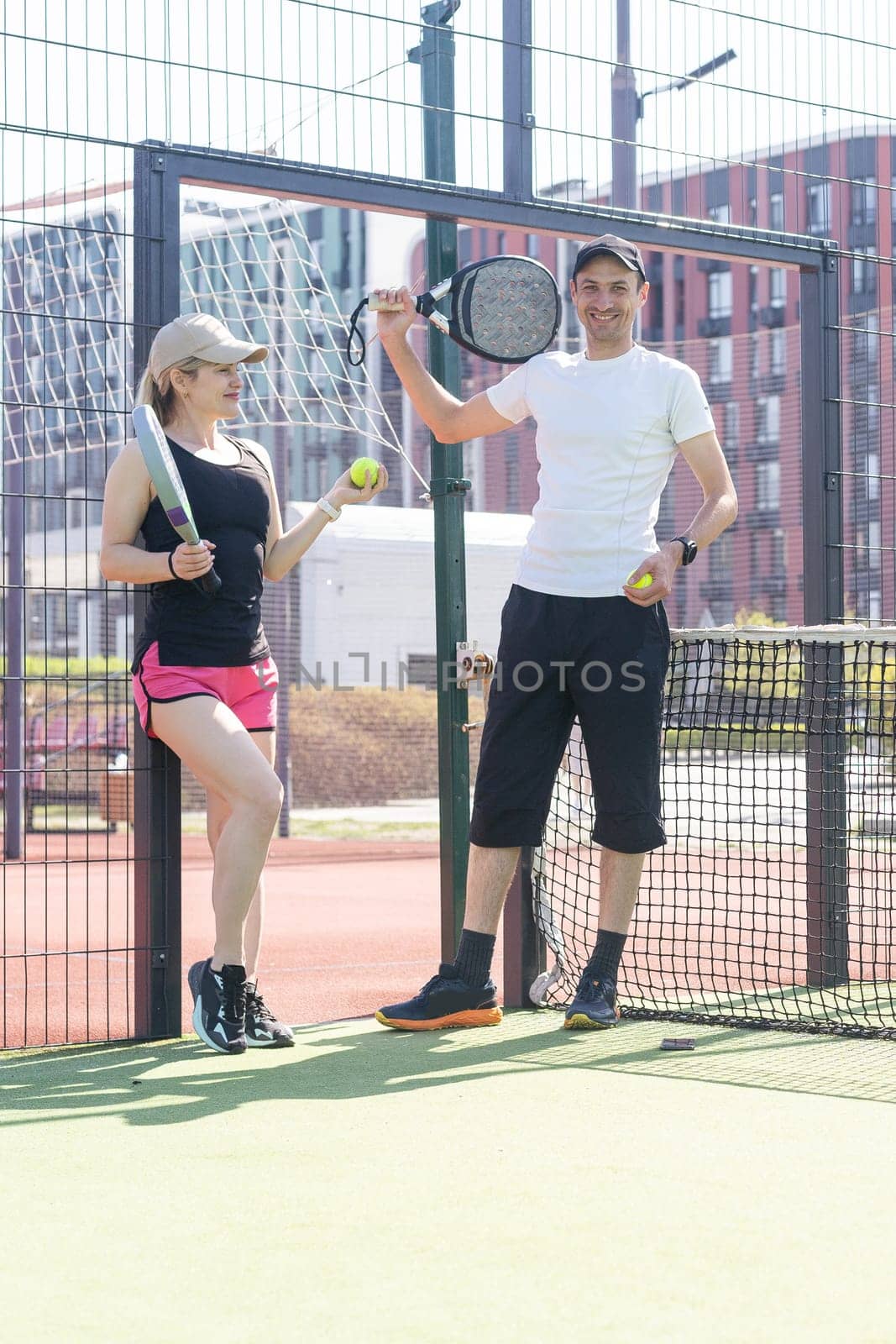Portrait of two smiling sportsman's posing on padel court outdoor with rackets - Padel players. High quality photo