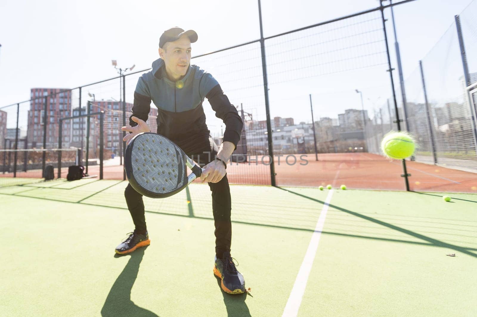 Man playing padel in a green grass padel court indoor behind the net. High quality photo