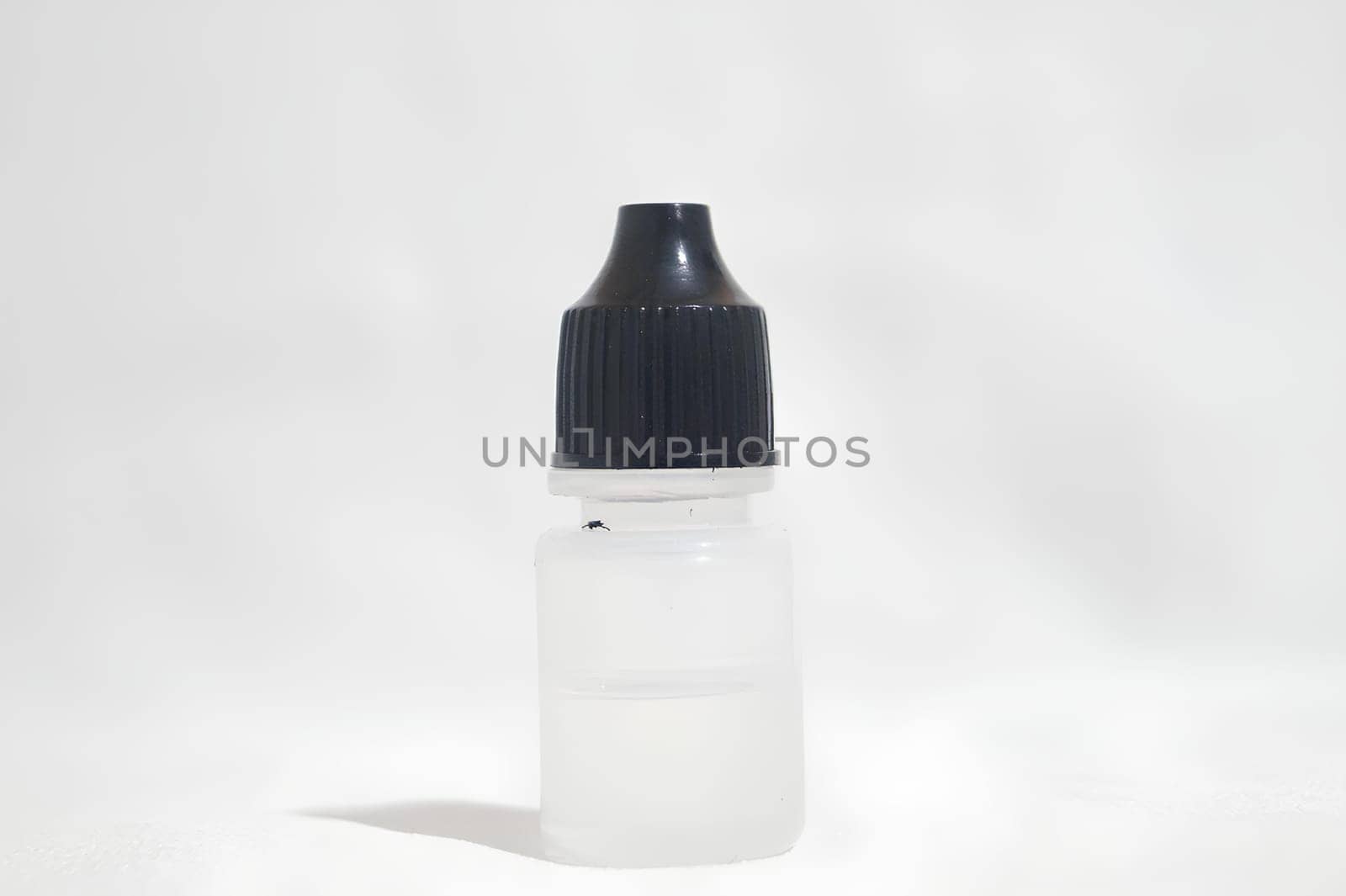 Small Bottle with Black Cap on White Background. High quality photo