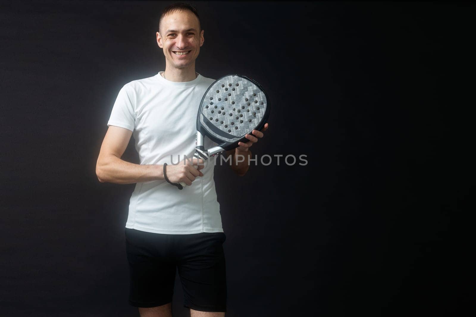 Man ready for paddle tennis serve in studio shot. High quality photo
