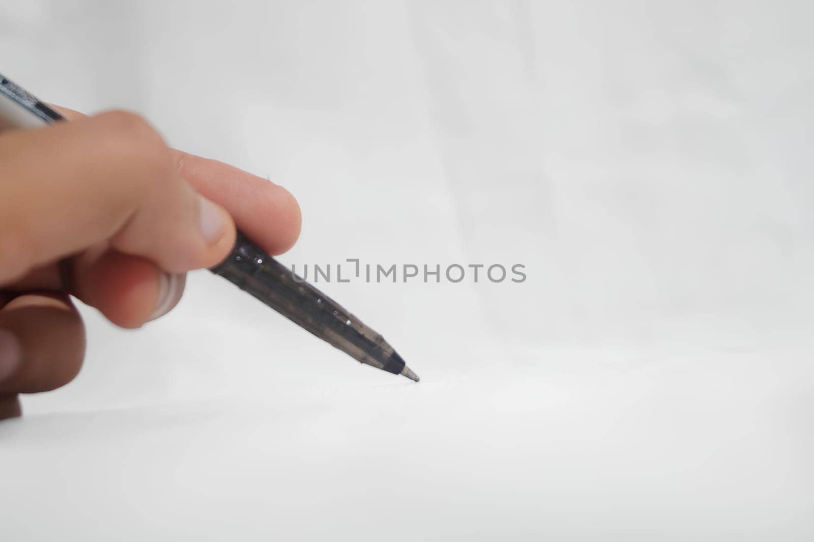 A person is writing with a pen on a white background. High quality photo