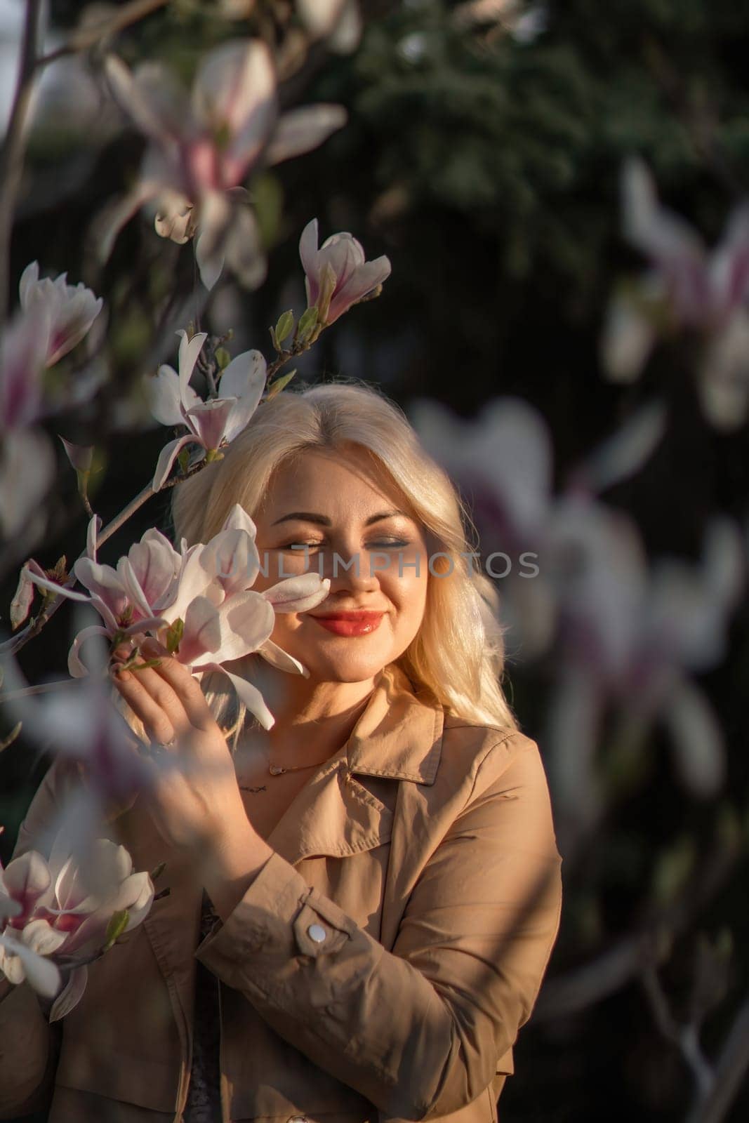 A woman is holding a magnolia flower in her hand and standing in front of a tree. Concept of serenity and beauty, as the woman is surrounded by nature and the flower adds a touch of color. by Matiunina