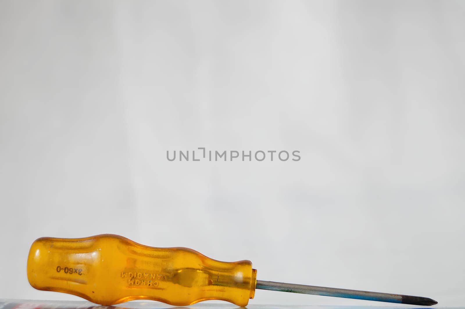 A yellow screwdriver with a silver tip. High quality photo