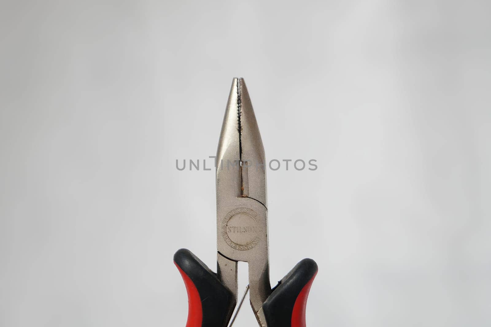 A pair of pliers with a silver head and black handles. High quality photo