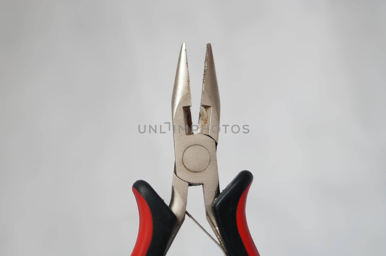 A pair of pliers with a black handle and a silver head. High quality photo