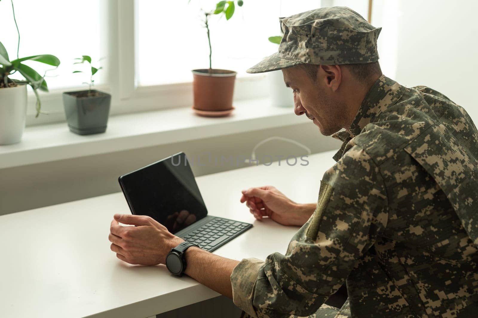 Caucasian soldier in army uniform in front of computer feeling happy and excited. American soldier receiving good news. High quality photo