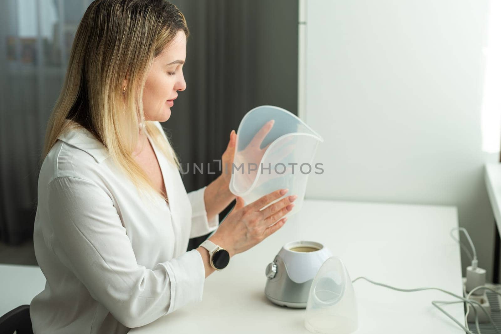 Beautician holding ultrasound device for face and skin lifting procedure and hair removal. Young woman cosmetologist using modern cosmetology equipment in clinic. High quality photo