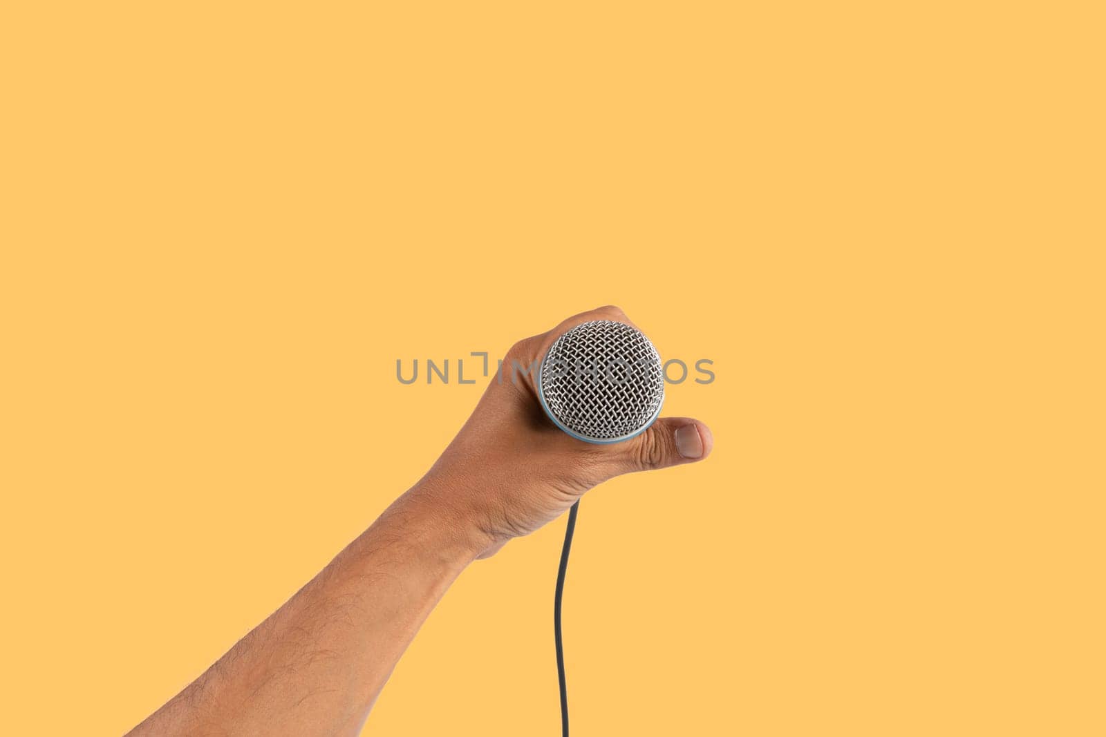 Black male singer hand holding a microphone isolated on yellow background by TropicalNinjaStudio