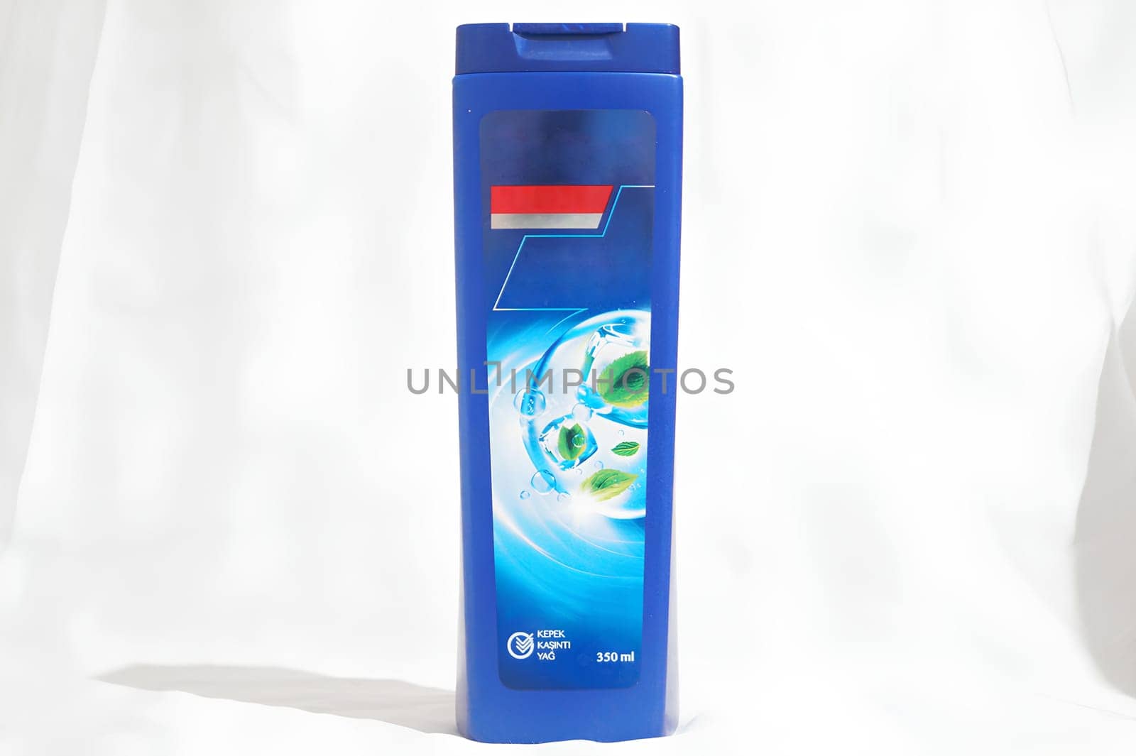 A blue bottle of shampoo with a blue cap. High quality photo