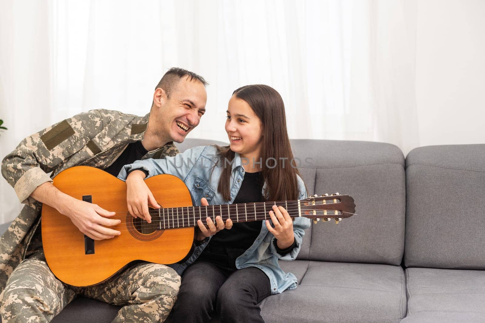 a veteran and his daughter play the guitar. High quality photo