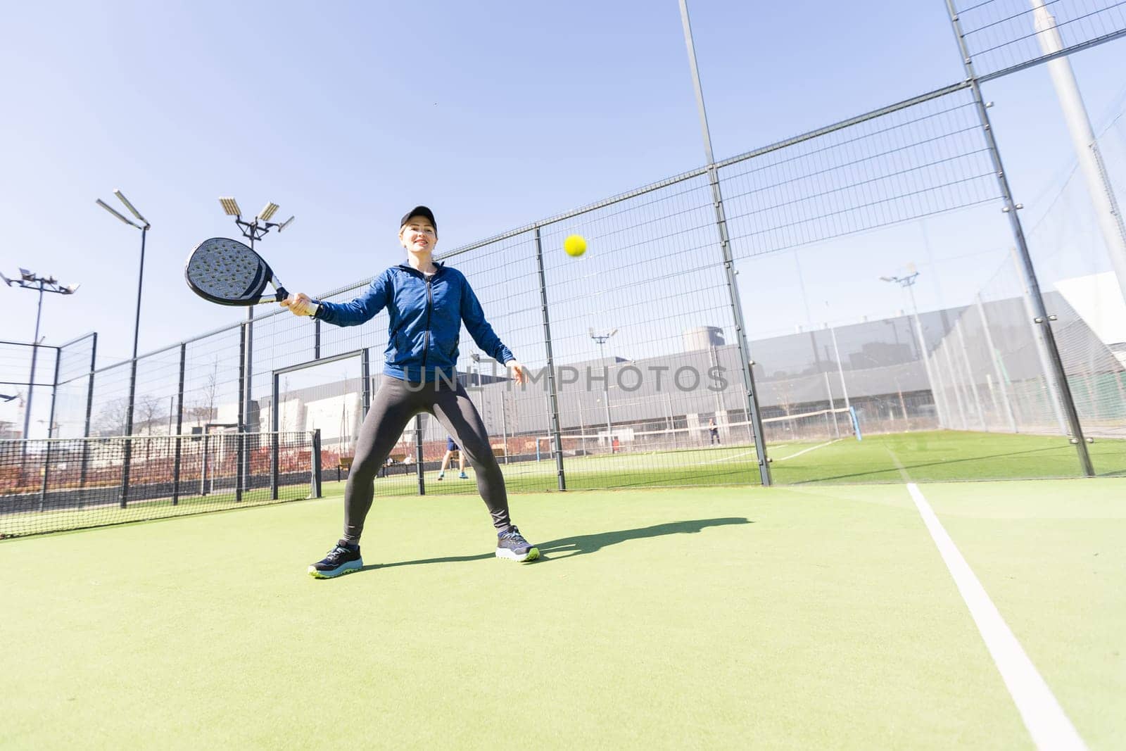 Determined sporty young woman playing padel in court. High quality photo