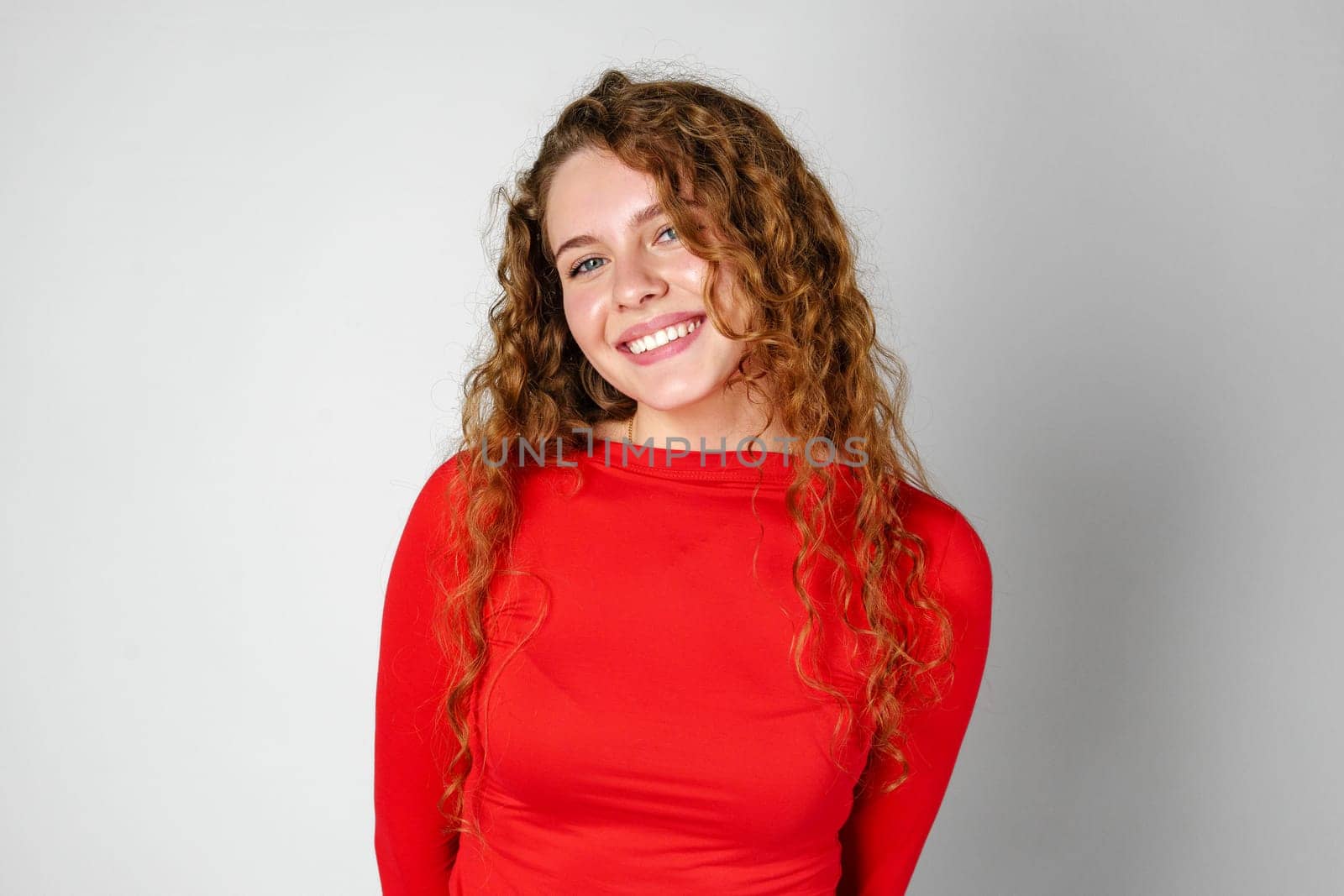 Young Woman With Curly Hair Portrait against gray background in studio